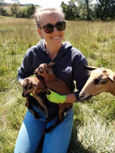 Photo of Aubrey Smiling holding baby goats
